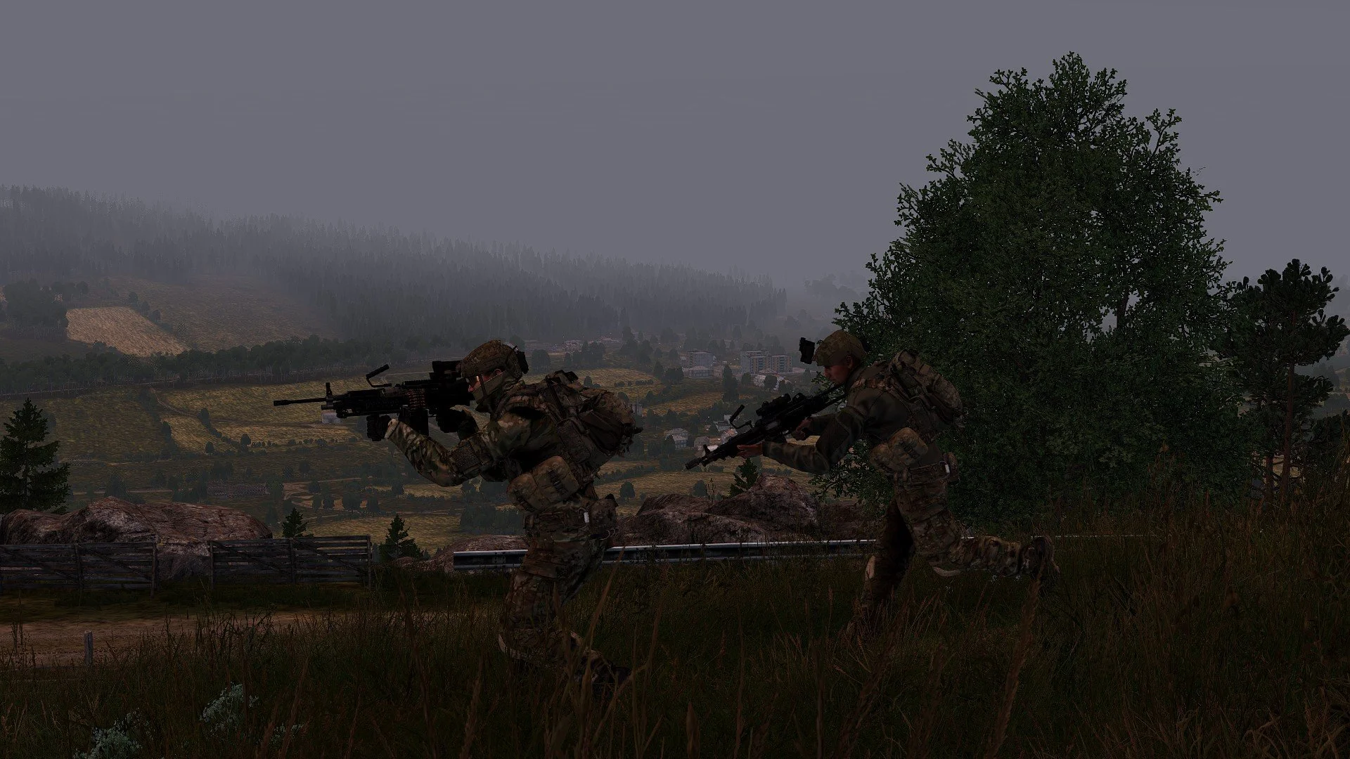 Two soldiers in camouflage uniforms running through a grassy field with trees, rocks, and a landscape with hills and a town in the background during dusk or dawn.