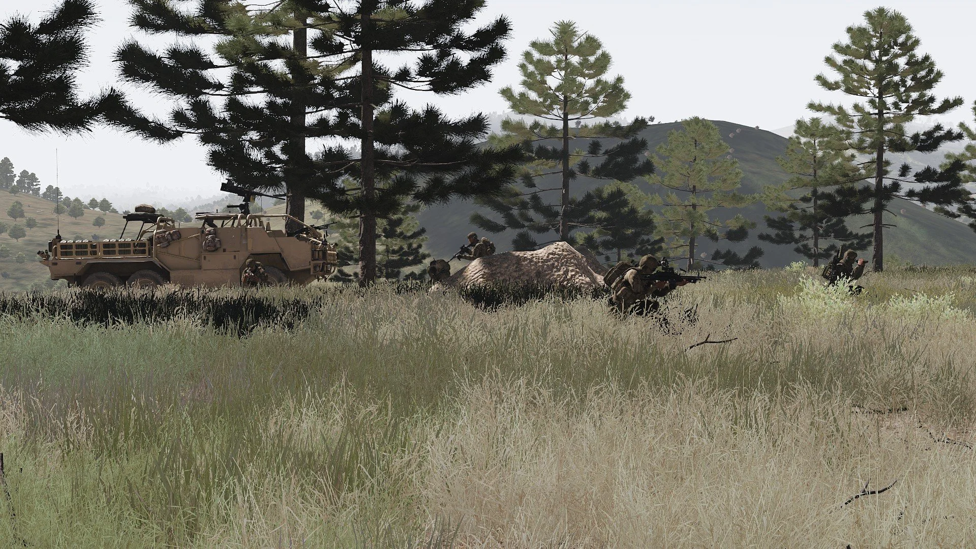 A group of soldiers in camouflage uniforms crouching and aiming weapons in a grassy forested area with tall pine trees and hills in the background. There is a military vehicle parked nearby.