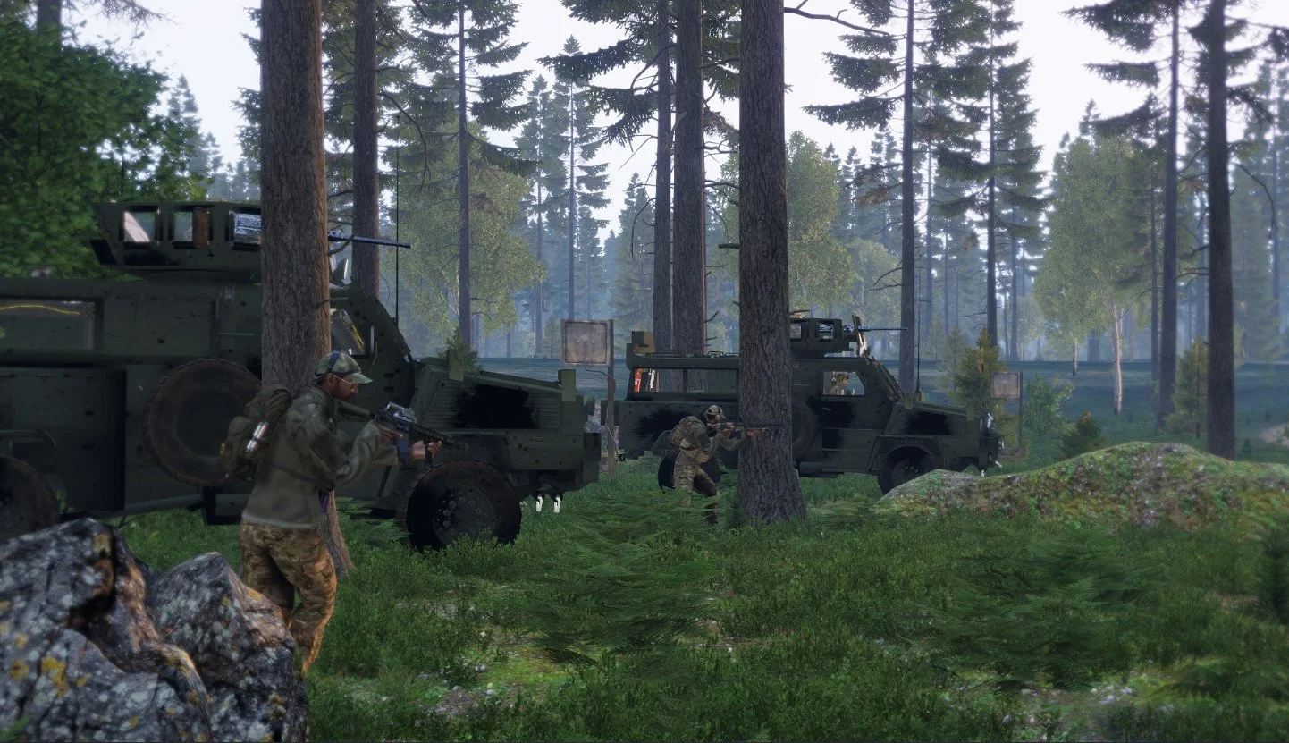 Video game scene depicting military soldiers hiding behind trees in a forest, with two armored vehicles nearby, aiming their guns.
