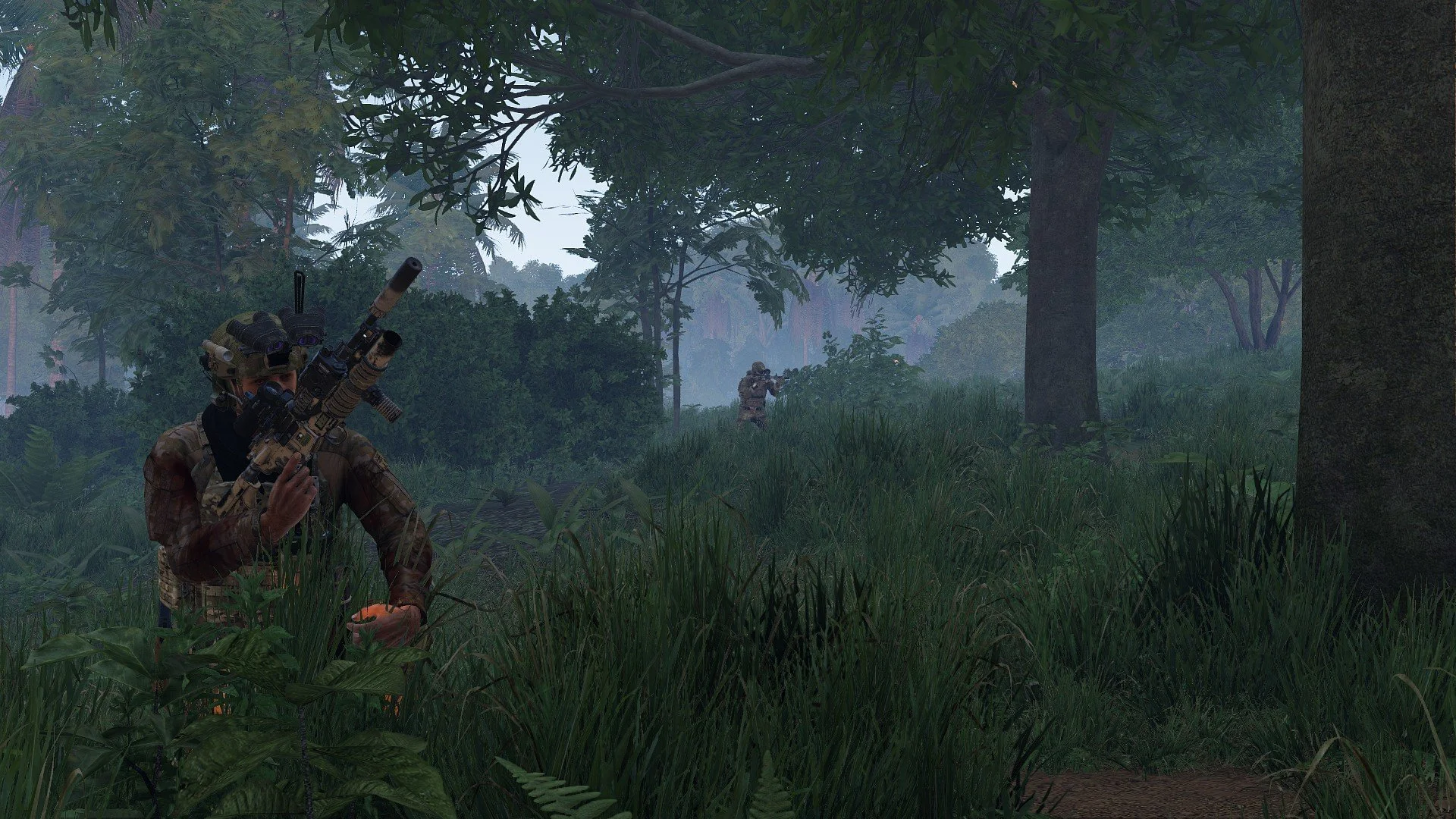 A soldier wearing camouflage gear and night vision goggles peering through the tall grass in a dense forest, aiming a rifle with another soldier in the background.