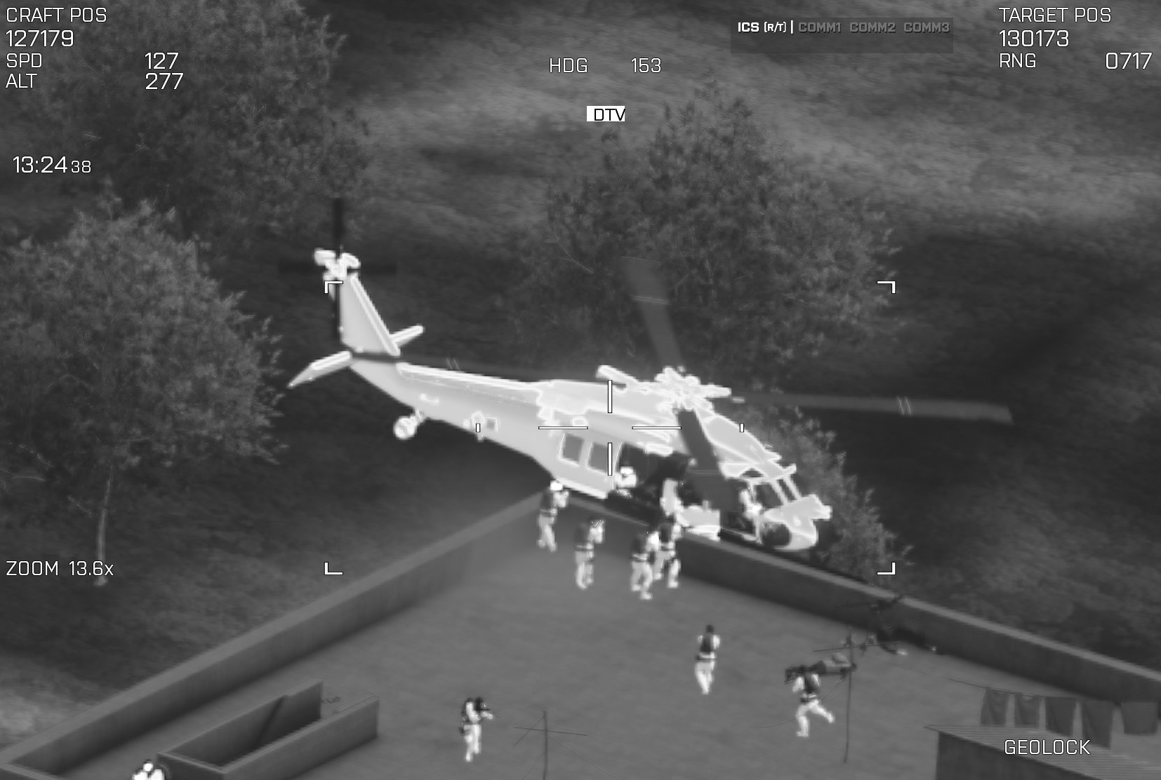 Night vision image of a military helicopter on a rooftop, with personnel around it, some walking and some possibly preparing for a mission.