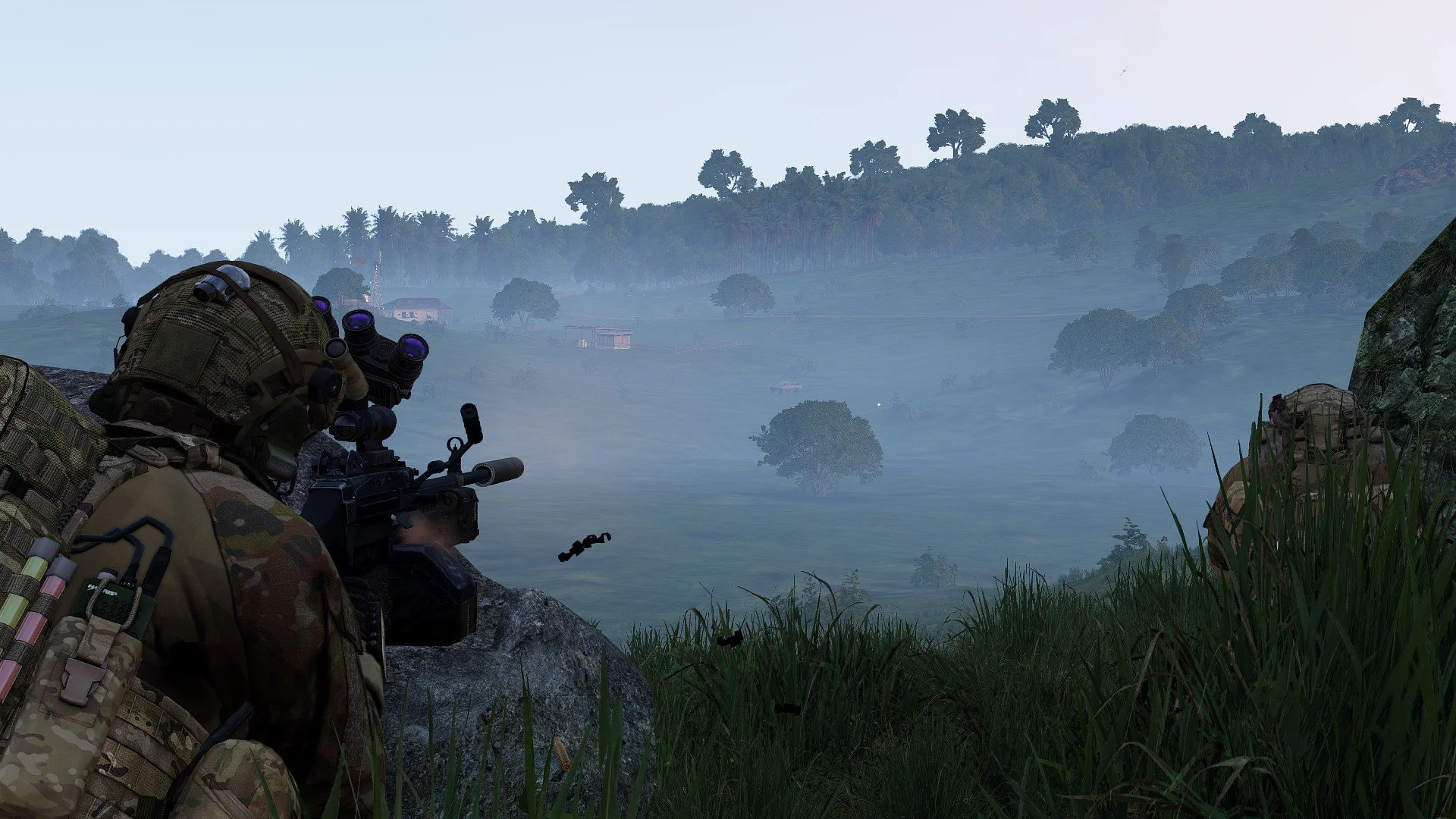 Soldier aiming a rifle with a scope while crouching behind rocks and grass in a foggy, hilly landscape.